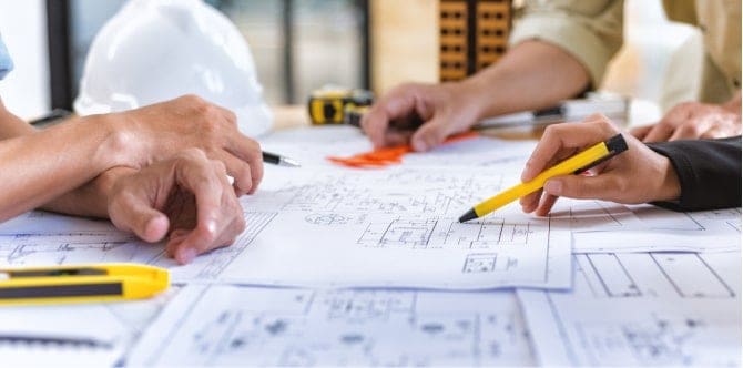 Three people reviewing plans