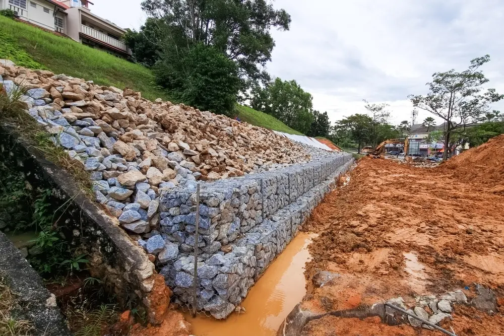 Series of slope retention construction design with rocks and mesh to manage landslide